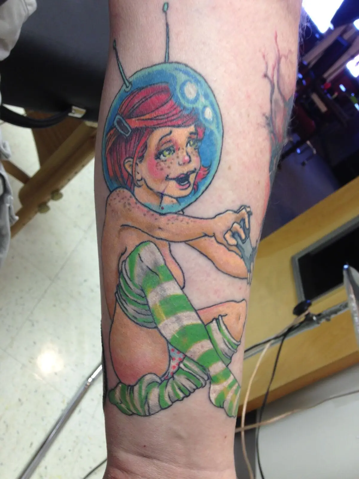 Color illustrative space-girl with fishbowl helmet forearm tattoo